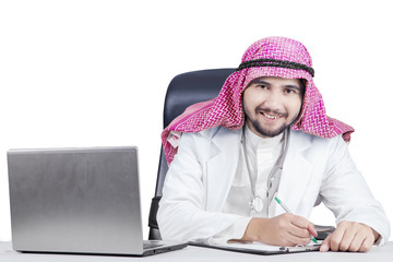 Wall Mural - Friendly Arabian doctor working on table