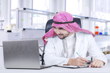 Wall Mural - Muslim doctor with laptop in hospital