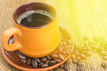 black coffee in brown cup pottery and roasted coffee beans on ta