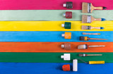 Fototapeta Tęcza - a set of paint brushes on a wooden surface,colored board