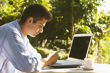 young man with mobile and laptop