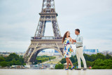 Fototapeta Paryż - Romantic loving couple having a date near the Eiffel tower