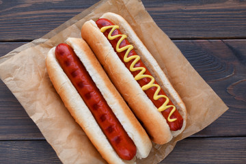 Barbecue Grilled Hot Dog with Yellow Mustard and ketchup on wooden table. Fast food.