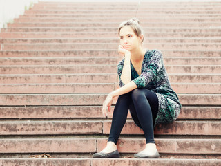 Sad girl sitting on steps