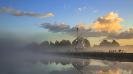 Wall Mural - Historic Wooden windmill under beautiful warm sunrise