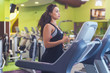 © undrey - Fit woman exercising on treadmill in gym.