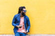 © santypan - African Young Man Using Mobile In The Street.