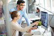 © pressmaster - Two colleagues having business discussion in modern office, woman analyst showing successful financial and marketing statistics from screen to her male co-worker, sitting at desk with laptop computer