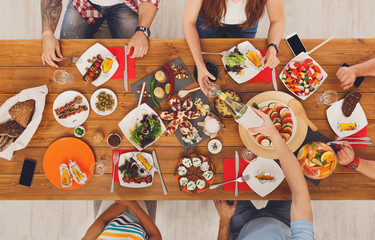 Wall Mural - People eat meals drink alcohol at festive table dinner party