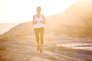 Wall Mural - Caucasian woman jogging at seashore