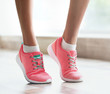 © Africa Studio - Woman wearing pink sneakers on blurred background