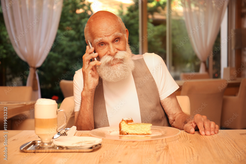 Elderly man sitting at dinner table  in a restaurant