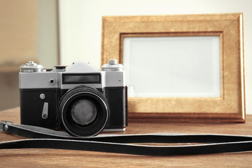 Wall Mural - Vintage camera and frame on wooden table