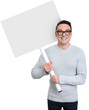 © spaxiax - Smiling young casual man holding blank placard