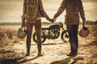 © Nejron Photo - Stylish cafe racer couple on the vintage custom motorcycles in a field.