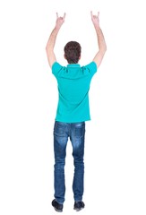 back view of dancing young man. Curly man in a turquoise jacket waving his hands to the music.