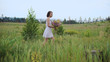 © kustvideo - Beautiful inspired woman talking on a blossoming field with a bouquet of wildflowers.