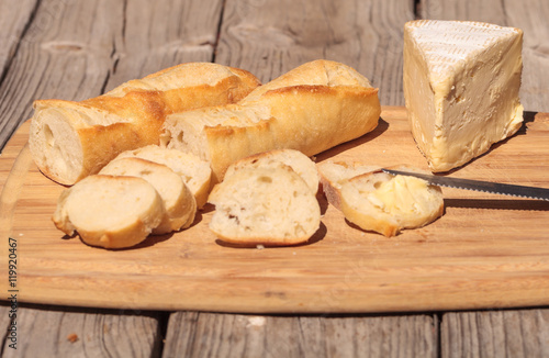Fotografia, Obraz French bread and triple cream brie cheese on a cutting board with a knife