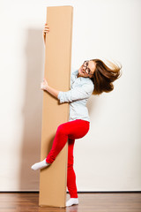 Wall Mural - Funny woman moving into apartment holding box.