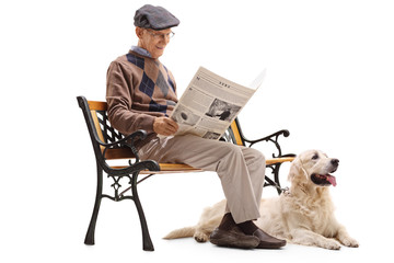 Canvas Print - Senior man reading a newspaper with his dog