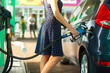 © vladstar - Woman fills petrol into the car at a gas station