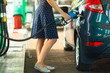 © vladstar - Woman fills petrol into the car at a gas station