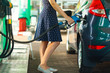 © vladstar - Woman fills petrol into the car at a gas station