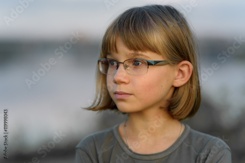 Sad Teenager Girl With Short Blonde Hair And Blue Eyes Against