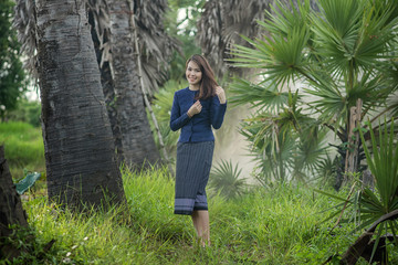 Thai Farmer woman wearing typical Thai dress, on Rice fields bac