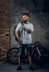 Wall Mural - Portrait of bearded hipster male with bag and bicycle.