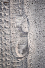 The Imprint Of The Shoe And The Wheels On The Sand