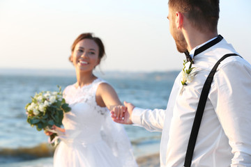 Groom and bride on bank of river