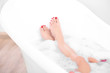 © Africa Studio - Woman legs with flower petals in bathtub