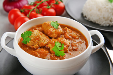 Poster - Tasty chicken curry in soup plate on grey background