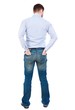 © ghoststone - back view of Business man looks. Bearded businessman standing with his hands in the back pockets of jeans.