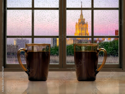 Two Mugs With A Hot Drink Tea Or Coffee On The Window Sill Of