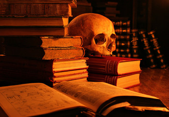 Memento Mori, Stillleben mit Totenschädel und alten Büchern, beleuchtet von Kerzenlicht