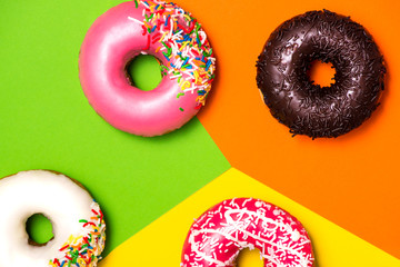 Donuts with icing on colorblock background. Sweet donuts.