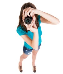 young woman in shorts photographed something compact camera. Isolated over white background.
