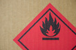 © substancep - Close-up detail of a fire hazard warning symbol on a cardboard cargo box containing chemicals.