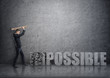 © gearstd - Side view of young businessman crashing 3D concrete 'impossible' words with a hammer