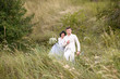 © ronedya - Young couple in love outdoor. Elegant bride and groom posing together outdoors on a wedding day. bride and groom in the Park. young couple in the woods. young couple in the grass. couple walking