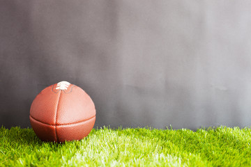 Vintage football over grass and black background