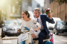  Newlyweds Having Fun On A Decorated Vintage Scooter