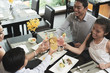© DragonImages - Asian family toasting at dinner table, view from above