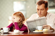© pressmaster - Little girl sitting back to her father who is reading paper