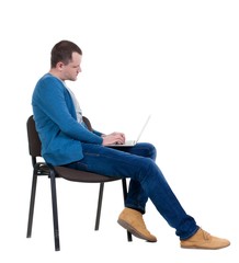 Canvas Print - Side view of a man sitting on a chair to study with a laptop. Isolated  over white background