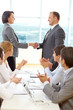 © pressmaster - Group of successful business people making a business deal at a meeting