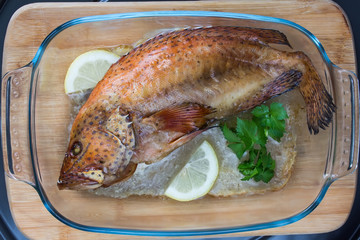 Wall Mural - Baked coral grouper with lemon and green celery in a glass tray