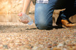Hipster man holding bottle of water at summer river